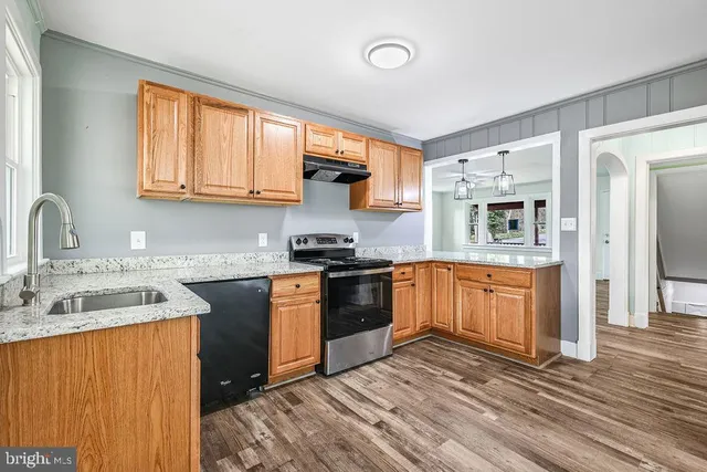 a kitchen view with wooden floor and a window