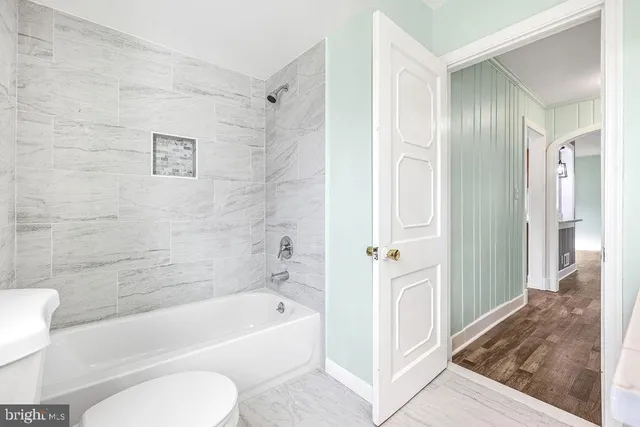 a bathroom with a tub shower and toilet