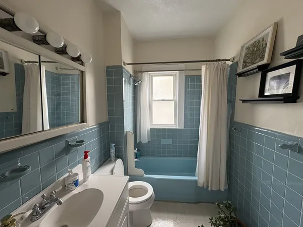 a bathroom with a sink a toilet a mirror and bathtub