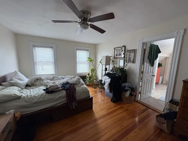 a bedroom with a bed and wooden floor