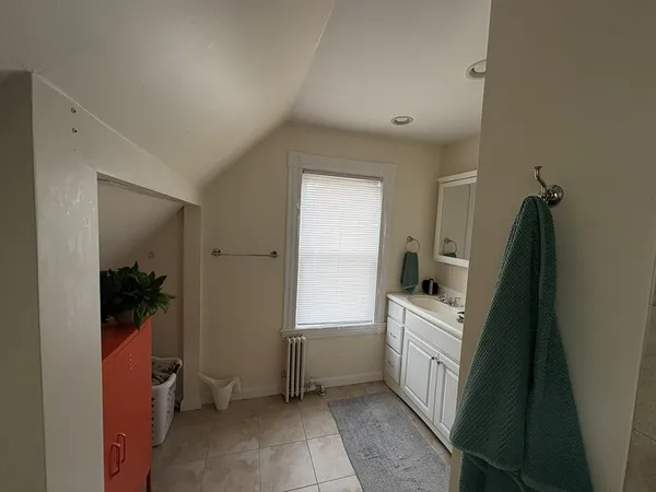 a bathroom with a sink and mirror with bathtub