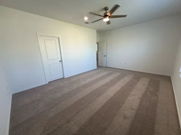 an empty room with ceiling fan and window