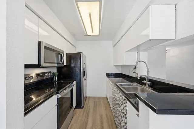 a kitchen with stainless steel appliances granite countertop a sink and a stove