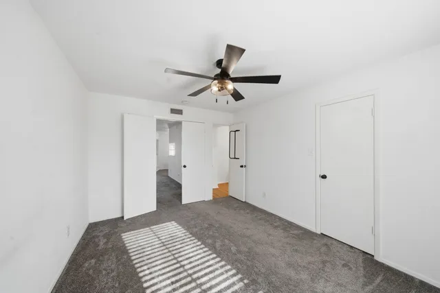 a bedroom with a bed and a chandelier fan