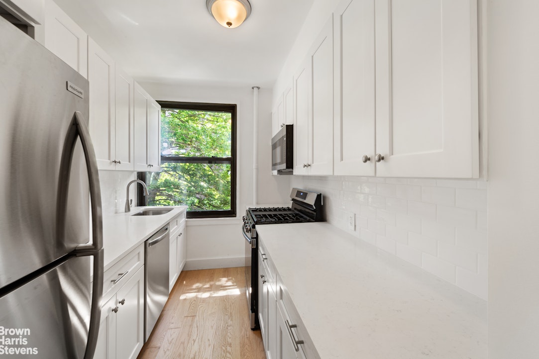 98-41 64th Road, Unit 3G Queens, NY 11374 - Photo 3 of 14 a kitchen with a refrigerator a sink and a window