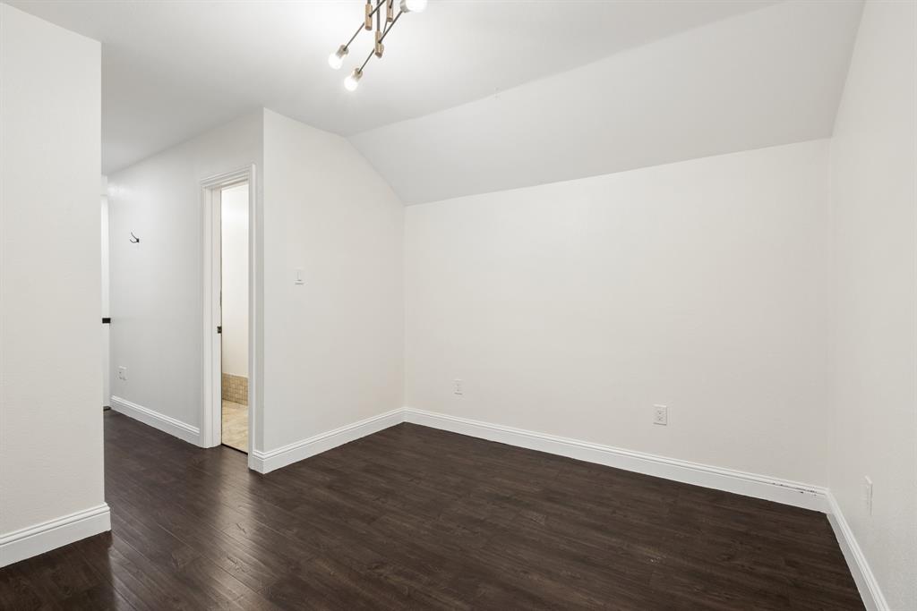 15539 Preston Road, Unit 1037 Dallas, TX 75248 - Photo 30 of 36 Dark wood-finish flooring with white baseboards, crisp white walls, and a contemporary ceiling light fixture