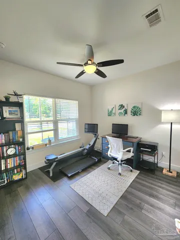 a living room with furniture gym equipment and a large window