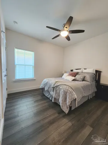 a spacious bedroom with a bed and wooden floor