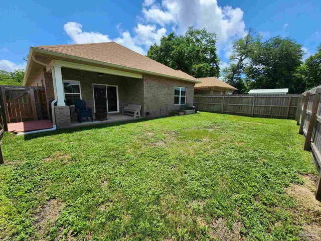 a view of a house with backyard and porch