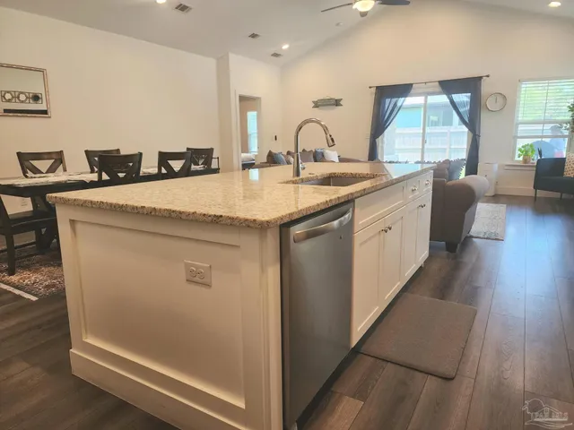 a en suite bathroom with a granite countertop sink a mirror and bathtub