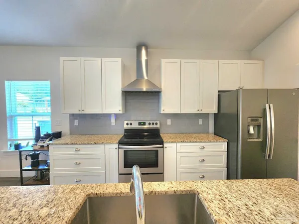 a kitchen with a stove a refrigerator and a stove top oven