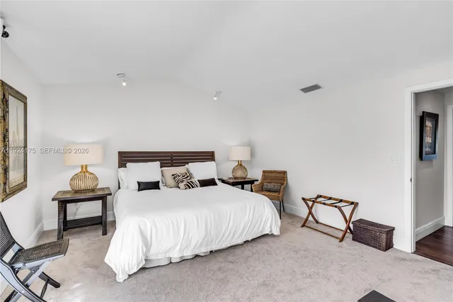 a bedroom with a bed a mirror and lamp