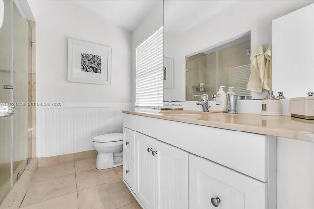 a bathroom with a granite countertop sink a toilet and a mirror