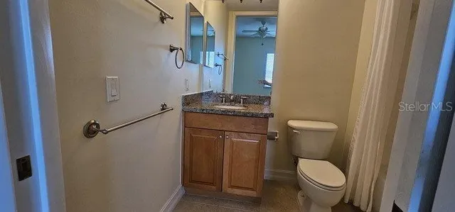 a bathroom with a granite countertop toilet and a sink