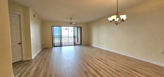 a view of a room with wooden floor and chandelier