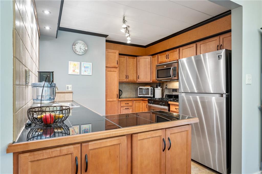 5 Bayard Road, Unit 203 Pittsburgh, PA 15213 - Photo 4 of 21 a kitchen with stainless steel appliances granite countertop a refrigerator a stove and a sink with cabinets