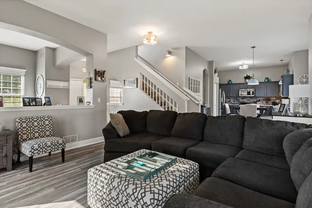 a living room with furniture lamp and a view of kitchen