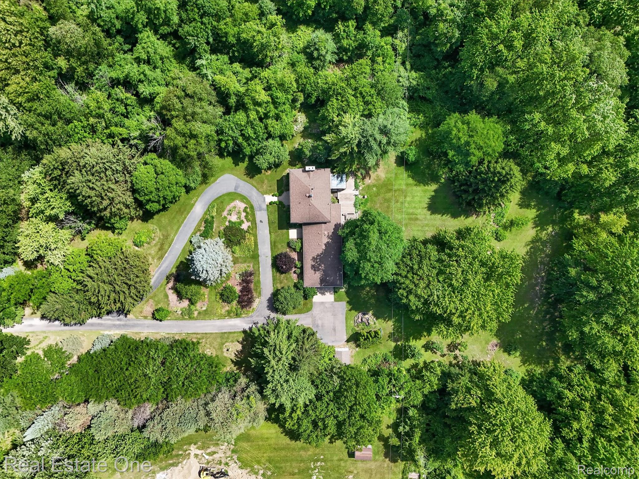 6039 Fish Lake Road Holly, MI 48442 - Photo 55 of 64 Expansive property featuring a brown-roofed residence, a winding paved driveway, mature trees, manicured lawns, and substantial green space