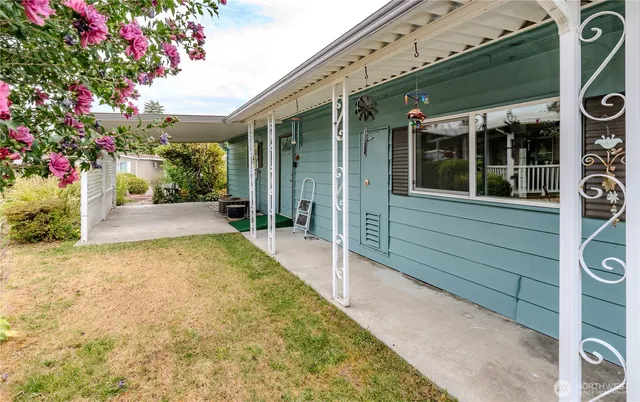 a view of a backyard with plants and brick wall