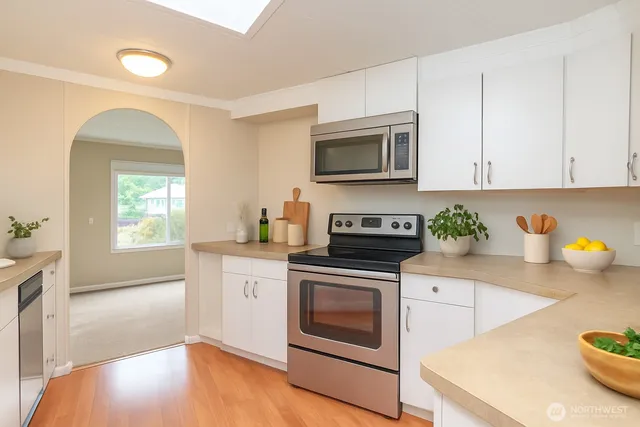 a kitchen with stainless steel appliances a stove a sink a microwave and cabinets