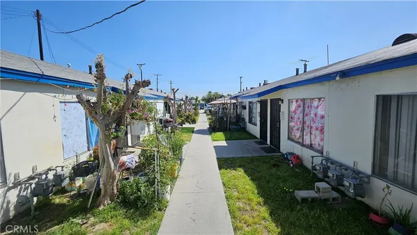 a front view of a house with a yard and potted plants