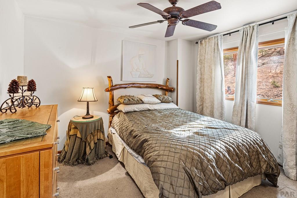 1301 Pheasant Loop Westcliffe, CO 81252 - Photo 15 of 27 a bedroom with a bed and ceiling fan