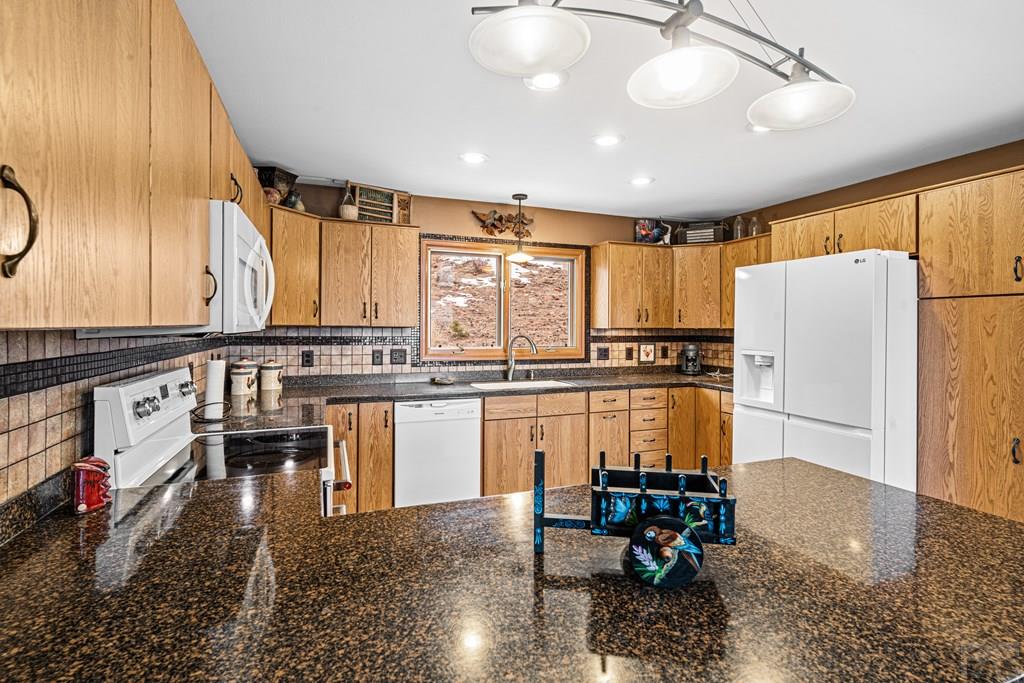 1301 Pheasant Loop Westcliffe, CO 81252 - Photo 10 of 27 a kitchen with refrigerator and chairs