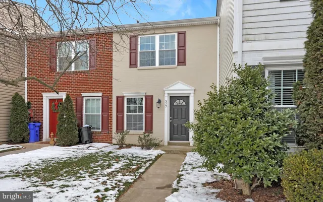 a view of a brick house with plants and large windows