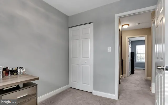 a view of a kitchen from the hallway with closet and a fireplace