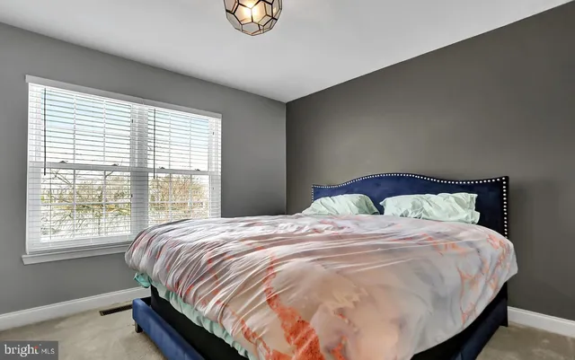 a large bed sitting in a bedroom next to a window