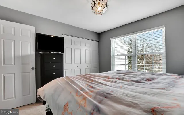 a bedroom with a bed and a flat tv screen