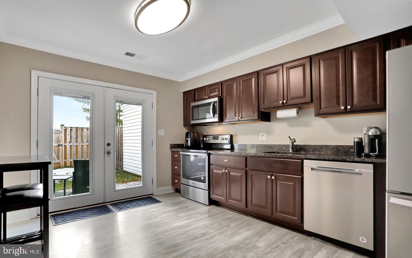 577 Lancaster Place Frederick, MD 21703 - Photo 5 of 19 a kitchen with stainless steel appliances granite countertop a stove a sink dishwasher and a microwave oven with cabinets