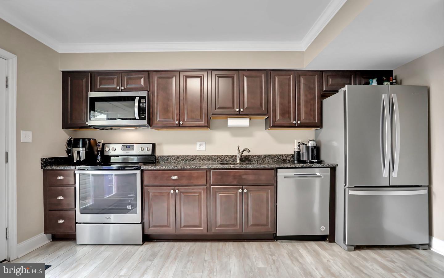 577 Lancaster Place Frederick, MD 21703 - Photo 8 of 19 a kitchen with stainless steel appliances granite countertop a refrigerator stove and sink with wooden cabinets