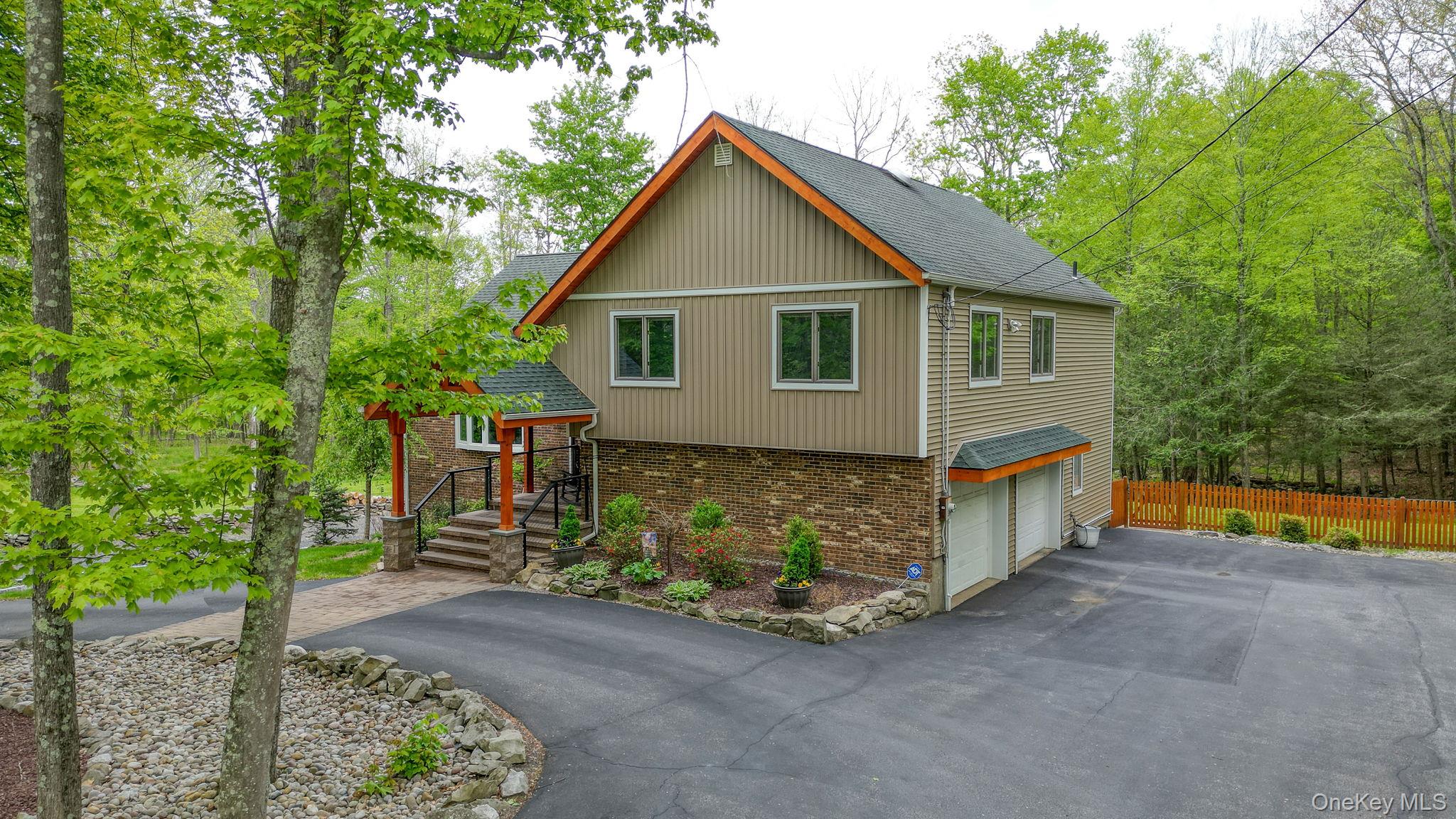 a front view of house with yard and trees in the background