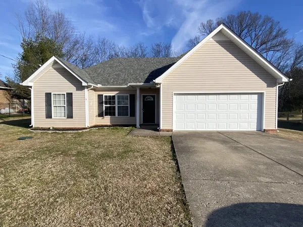 a view of a house with a yard and garage
