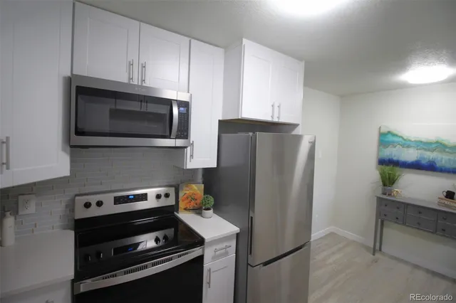 a kitchen with stainless steel appliances a refrigerator a stove and a cabinets