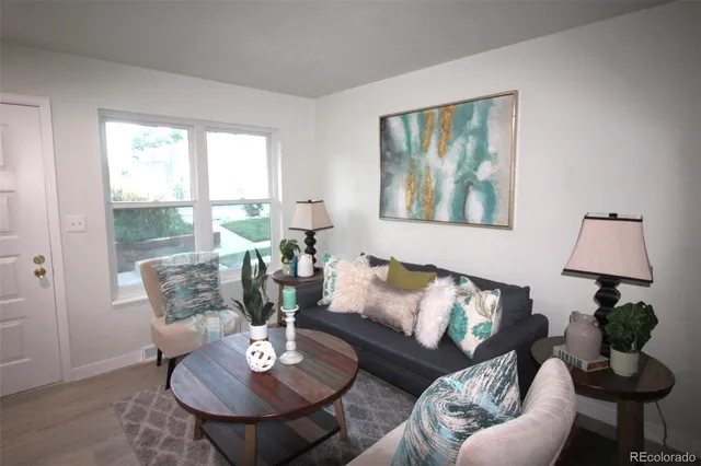 a living room with furniture a lamp and a potted plant