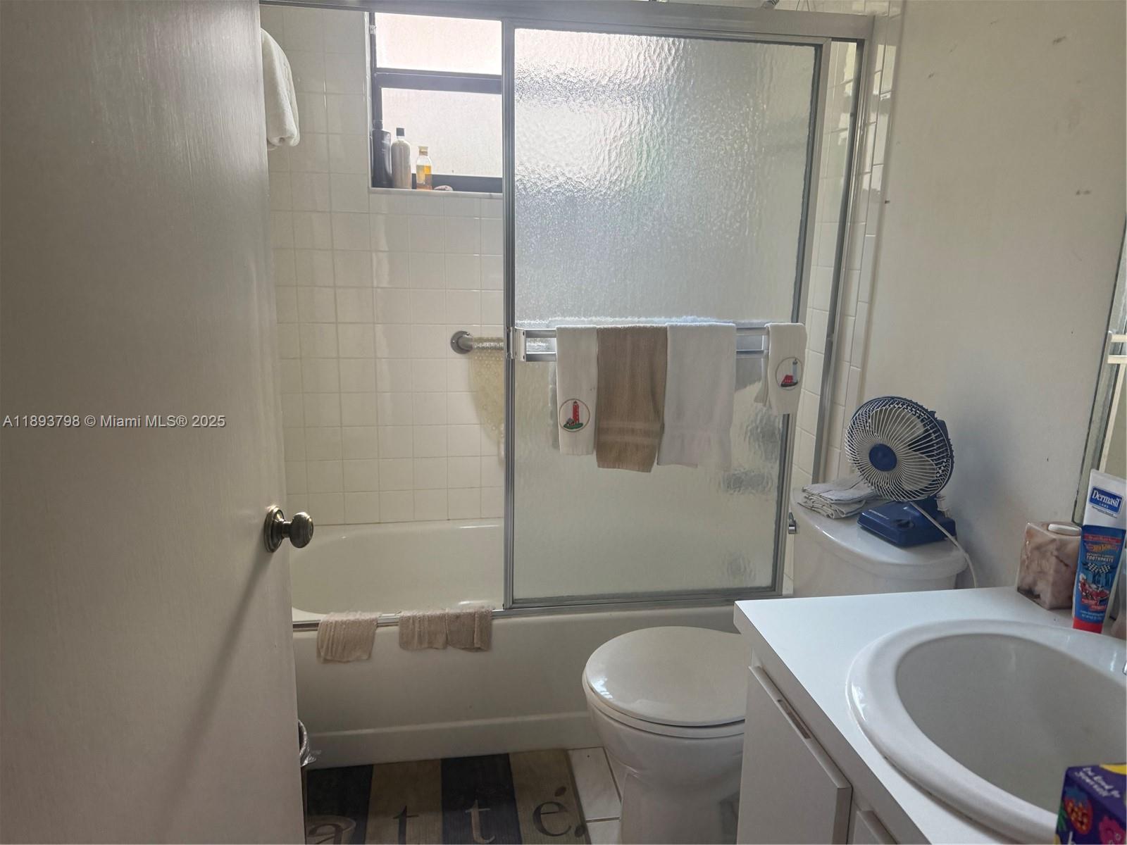 831 Northeast 207th Lane, Unit 2106 Miami, FL 33179 - Photo 12 of 13 a bathroom with a sink toilet and shower