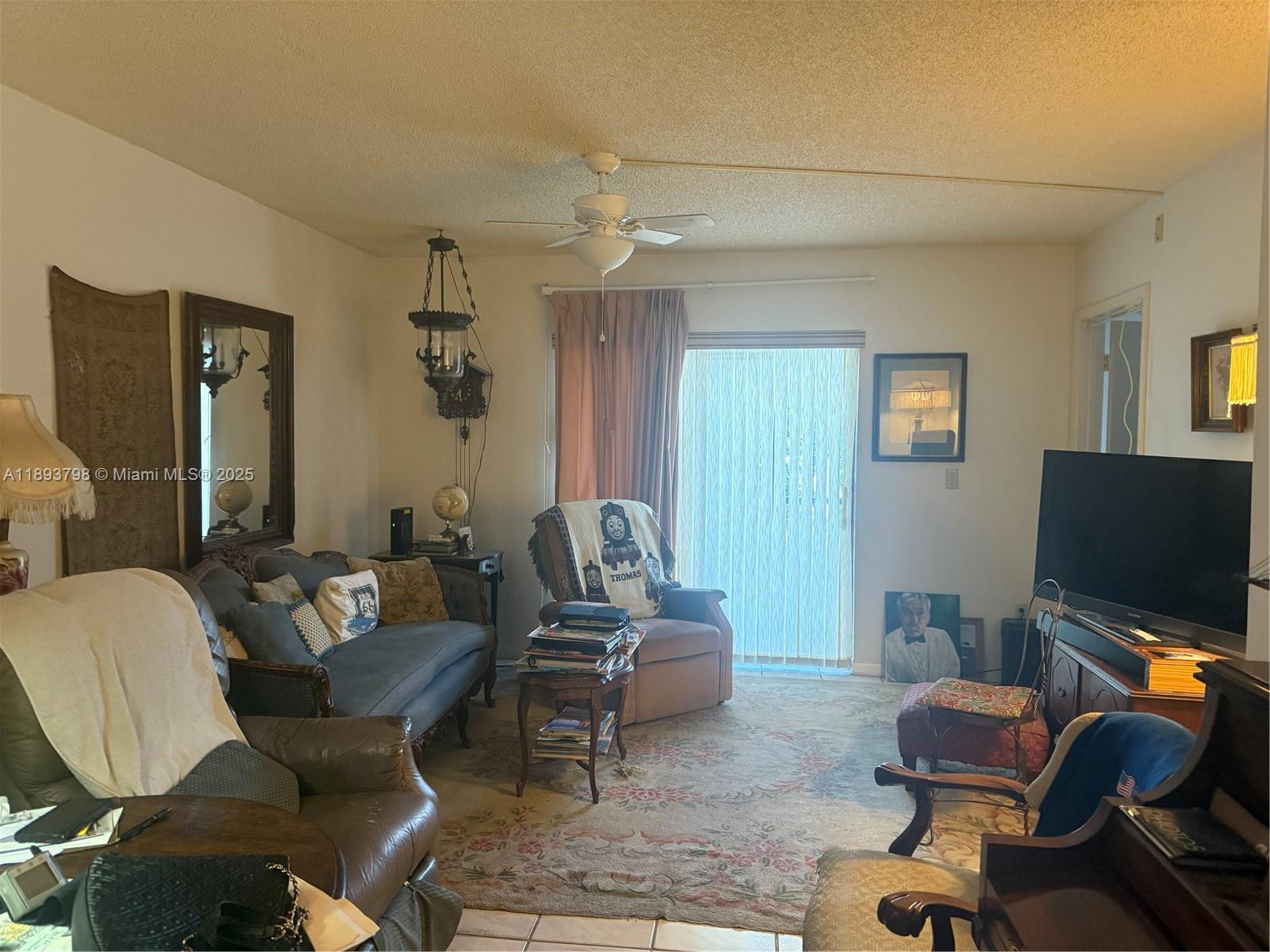 831 Northeast 207th Lane, Unit 2106 Miami, FL 33179 - Photo 13 of 13 a living room with furniture and a flat screen tv