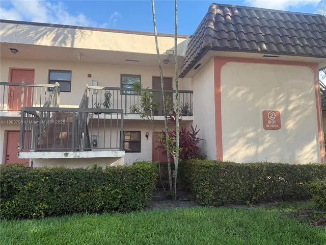 a view of a house with a small yard and a wooden fence