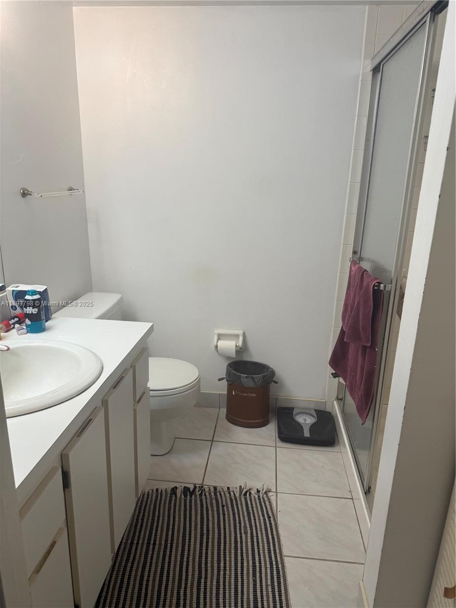 831 Northeast 207th Lane, Unit 2106 Miami, FL 33179 - Photo 5 of 13 a bathroom with a sink and a toilet