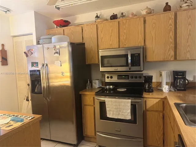 a kitchen with a refrigerator and a stove top oven