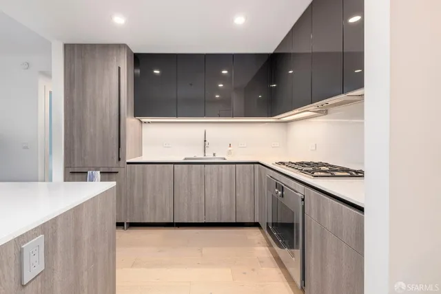 a kitchen with stainless steel appliances granite countertop a sink a stove and a refrigerator