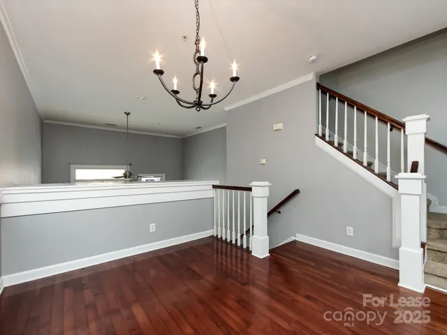 a view of a room with wooden floor and staircase