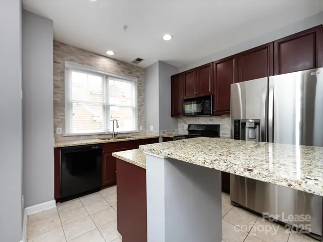 a kitchen with stainless steel appliances granite countertop refrigerator sink microwave and stove