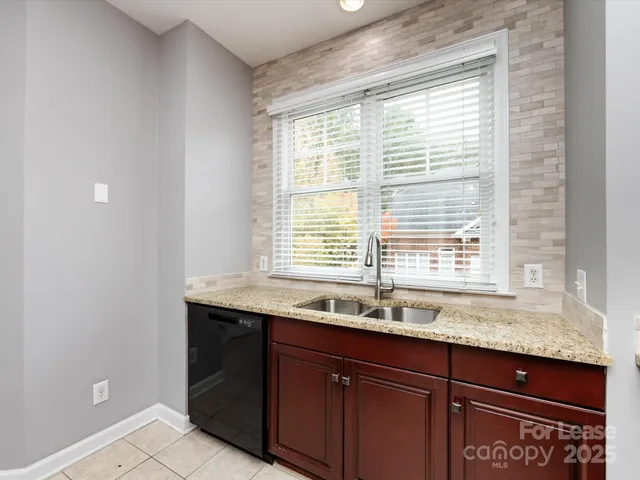 a bathroom with a granite countertop sink and a window