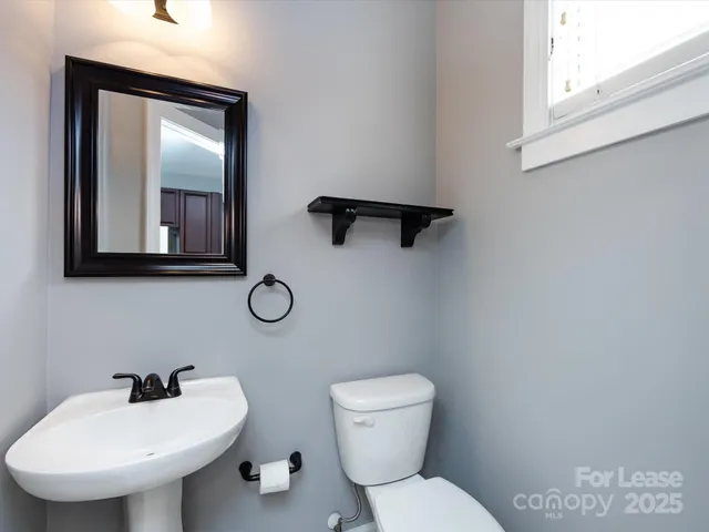 a bathroom with a toilet sink and mirror