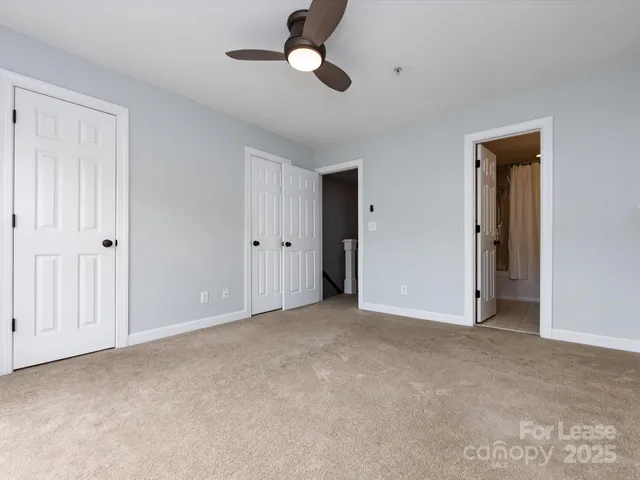 a view of an empty room with a ceiling fan