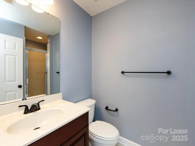 a bathroom with a sink a toilet and mirror
