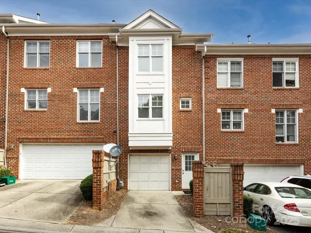 a front view of a house with a yard and parking space